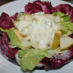 Käse und Birne auf einem Salatbett